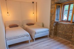 two beds in a room with a window at Casa Angelo in Nerezine