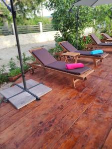 two lounge chairs and an umbrella on a wooden deck at Apartment Karla SNB in Lozovac