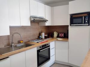 a kitchen with white cabinets and a sink at L'incontournable, centre ville parking WIFI in Vannes