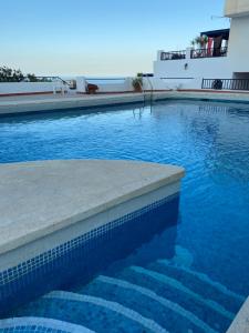 a swimming pool with blue water next to a building at SHIOKAZE in San José