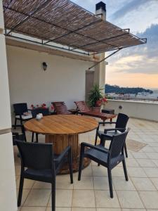 a patio with a wooden table and chairs on a roof at V for the View in Patra