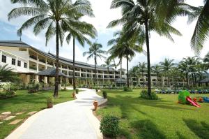 a resort building with palm trees and a fire hydrant at Khaolak Orchid Beach Resort - SHA Extra Plus in Khao Lak