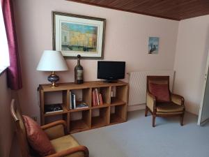 a living room with a television and two chairs at Calme et verdure in Buxerolles