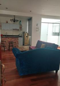 sala de estar con sofá azul y cocina en Depa Excelente Vintage, en La Molina
