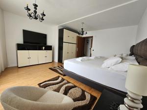 a bedroom with a bed and a chair and a television at Residence Gordana 2 in Selce