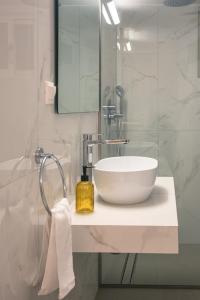 a bathroom with a white sink and a mirror at Coastal Getaway: Roomy Beachside Apartment! in Nea Makri