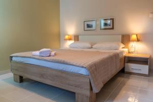 a bedroom with a bed with two towels on it at Coastal Getaway: Roomy Beachside Apartment! in Nea Makri