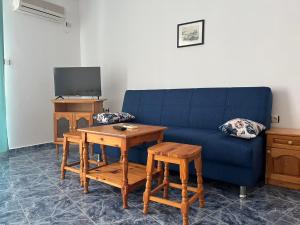 uma sala de estar com um sofá azul e uma mesa em Студио Одеса 22 em Sozopol