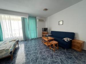 uma sala de estar com um sofá azul e uma cama em Студио Одеса 22 em Sozopol