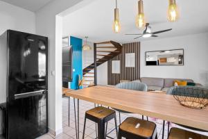 uma cozinha e sala de estar com mesa e cadeiras em Duplex standing et confort - Baby ready - 2 minutes de la plage Anse Mitan em Les Trois-Îlets