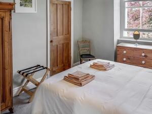 a bedroom with a bed with towels on it at Holly Bank Cottage in Settle