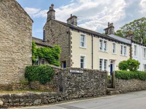 a stone wall in front of a house at Holly Bank Cottage in Settle