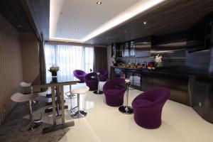 a kitchen with purple chairs and a table and a counter at The Perkin Hotel in Hong Kong