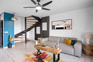 uma sala de estar com um sofá e uma mesa em Duplex standing et confort - Baby ready - 2 minutes de la plage Anse Mitan em Les Trois-Îlets
