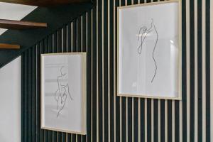 two drawings of flowers are on a wall at Duplex standing et confort - Baby ready - 2 minutes de la plage Anse Mitan in Les Trois-Îlets