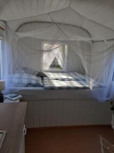 a small bed in a tent with a window at Rüdiger, der Bauwagen am Deich. 