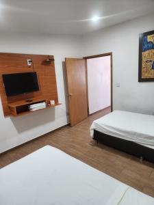 1 dormitorio con 1 cama y TV de pantalla plana en MOTEL PREMIER en Guadalajara