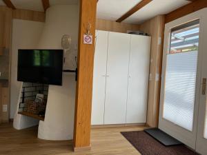 a living room with a large white cabinet and a tv at Tiny Haus Dornbirn in Dornbirn