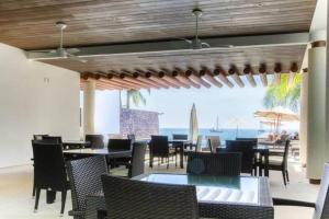 a restaurant with tables and chairs and a view of the ocean at Beautiful beach front apartment in Ixtapa. in Ixtapa