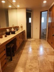 a bathroom with a sink and a large mirror at Beautiful beach front apartment in Ixtapa. in Ixtapa