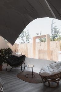 sala de estar con 2 sillas y mesa en Fuente del Lobo Glamping & Bungalows - Adults Only, en Pinos Genil