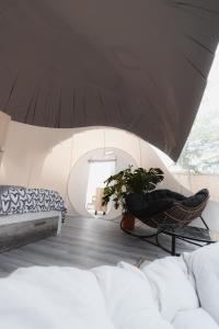 ein Wohnzimmer mit einem Sofa und einem Stuhl in der Unterkunft Fuente del Lobo Glamping & Bungalows - Adults Only in Pinos Genil
