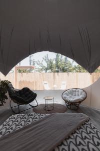 two chairs and a table under an umbrella at Fuente del Lobo Glamping & Bungalows - Adults Only in Pinos Genil