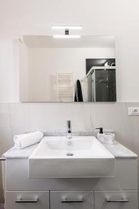 uma casa de banho branca com um lavatório e um espelho em Appartamenti Vacanza Mare em San Benedetto del Tronto