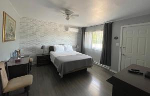 um quarto com uma cama e uma parede de tijolos em Auberge Restwell Motel em Moncton