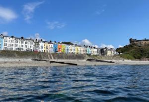 a view of a beach with buildings and the water at Môr Heli Guest House Criccieth in Criccieth