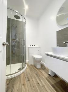 een badkamer met een douche, een toilet en een wastafel bij Môr Heli Guest House Criccieth in Criccieth