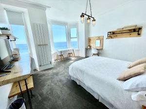 um quarto com uma cama e vista para o oceano em Môr Heli Guest House Criccieth em Criccieth