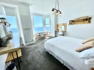 a bedroom with a bed and a view of the ocean at Môr Heli Guest House Criccieth in Criccieth