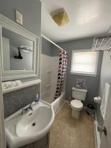La salle de bains est pourvue d'un lavabo blanc et de toilettes. dans l'établissement Auberge Restwell Motel, à Moncton