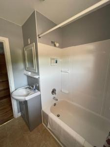 a bathroom with a bath tub and a sink at Auberge Restwell Motel in Moncton