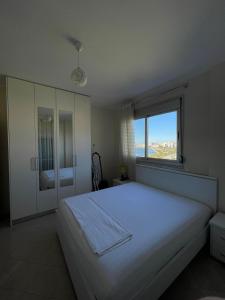 a bedroom with a large white bed and a window at ANISA Vlore in Vlorë