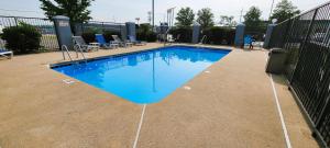 une grande piscine bleue entourée de chaises dans l'établissement Baymont by Wyndham LaVergne, à La Vergne