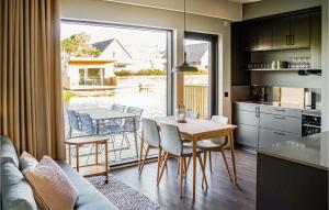cocina y comedor con mesa y sillas en Amazing Home In Strandlida With Sauna, Wifi And 2 Bedrooms, en Strandlida