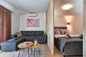 a living room with a couch and a bed at Tonka studio apartman in Križevci +37 photos