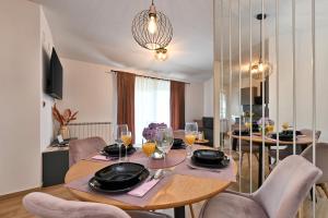 uma sala de jantar com uma mesa com copos de vinho em Tonka studio apartman em Križevci