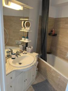 ein Badezimmer mit einem Waschbecken und einer Badewanne in der Unterkunft Appartement paisible, résidence avec piscine in Mandelieu-la-Napoule