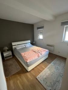 a bedroom with a bed and a rug and two windows at Villa Zak in Blagaj +18 photos