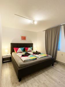 1 dormitorio con 1 cama grande y almohadas coloridas en FeWo Sonnenlay - Apartments an der Mosel, en Brauneberg