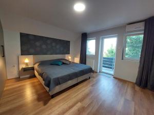 a bedroom with a bed and a large window at Boutique Villa Zala in Zalakaros