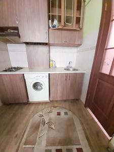 una pequeña cocina con fregadero y lavadora en 1ком апартаменты,парковка,улХорватская en Leópolis