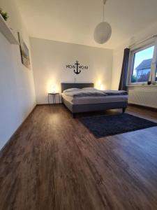 a bedroom with a bed and a wooden floor at FeWo Leo in Rastede