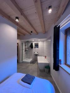 a bathroom with a tub and a sink and a bath tub at Chalet Des Legendes in La Combe