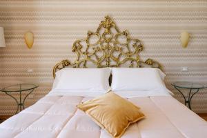 a white bed with a gold headboard and two tables at Amalpha Domus 100 sqm Apt with AC WiFi and balcony - 3rd floor, 50 steps in the Building in Amalfi