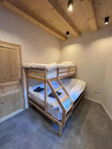 sypialnia z 2 łóżkami piętrowymi w pokoju w obiekcie Chalet Des Legendes w mieście La Combe