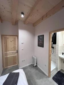 a bedroom with a bed and a door to a bathroom at Chalet Des Legendes in La Combe